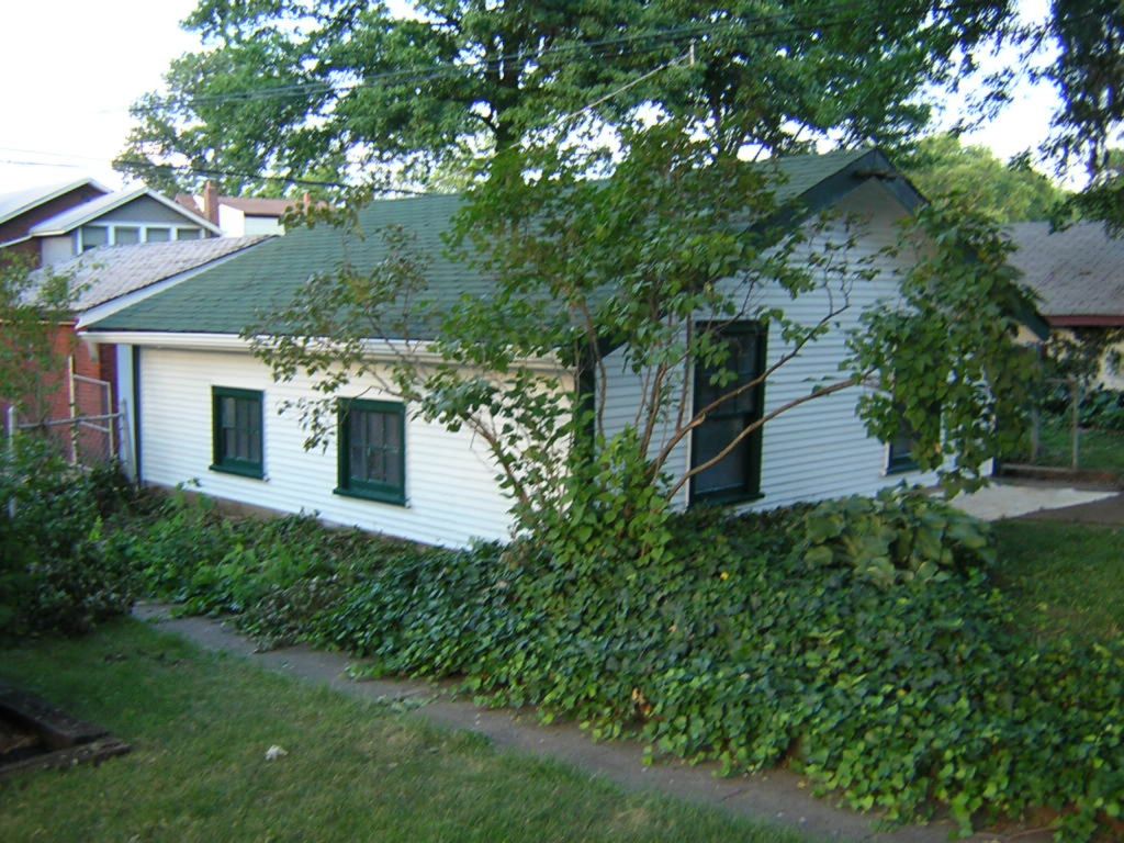 Side and back shot of completed City garage, white body and hunter green trim, green roof.